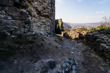 Antik taş duvarlar ve tarihi Nevytske Kalesi 'nden geçen bir patika vadiye bakan bir harabe.