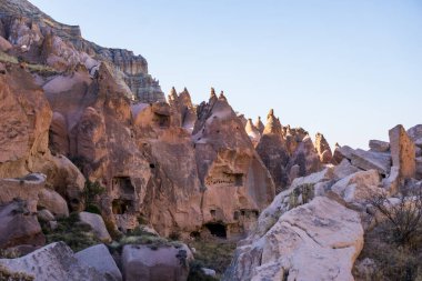 Türkiye 'nin Kapadokya bölgesinde eşsiz jeolojik oluşumların ve antik kaya kesimli evlerin panoramik bir görüntüsü, yumuşak güneş ışığıyla yıkandı