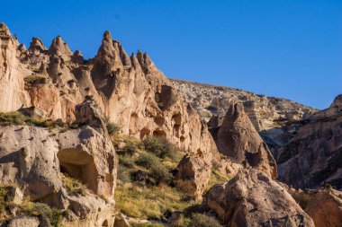 Türkiye 'nin Kapadokya kentinin dramatik manzarasında binlerce yıldır erozyonun oyduğu antik kaya oluşumları ve doğal bacalar yer alıyor.