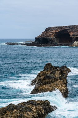 Okyanus tarafından oyulmuş ikonik Ajuy mağaraları derin mavi Atlantik sularına karşı görkemli bir şekilde volkanik kayalara çarpıyor.