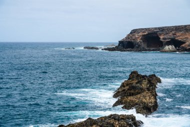 Dramatik Ajuy mağaraları ve volkanik kayalıklar Atlantik Okyanusu 'yla birleşir. Kayalık kıyılarda köpüklü dalgalar oluşur.