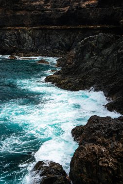 Ajuy, Fuerteventura 'nın engebeli kıyı şeridi antik volkanik kaya oluşumlarına karşı dalgalanan turkuaz dalgalar Atlantik Okyanusu' nun ham gücünü sergiliyor.