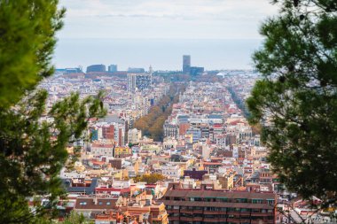 Barselona 'nın genişleyen bir şehir manzarası, uzak mavi denize doğru uzanan yoğun bir bina ve cadde koleksiyonunu gözler önüne seriyor.