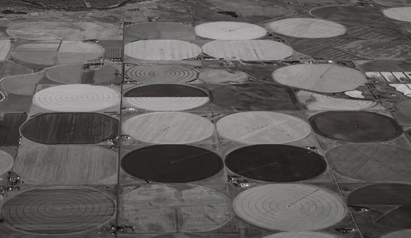 Çiftlik daireleri yukarıdan görüldüğü gibi siyah ve beyaz. Gri tonlarda tarım endüstrisinin yatay görüntüsü ve gökyüzünden gelen geometrik şekiller için yer var. Endüstriyel tarım arkaplanı ya da arka plan tam ve yarım daire.