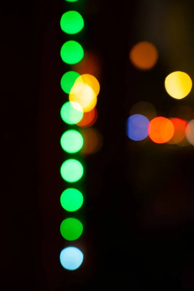 Bokeh ışıklarının soyut bulanıklığı yeşil turuncu ve kırmızı dairesel ışıkların bulanıklığı yumuşak odak noktasından Bokeh etkisi yaratarak bulanık görme ya da sarhoş sürüş kutlaması arka planının rengarenk görüntüsü dikey görüntü.