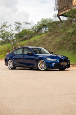 Mavi BMW M3 müsabakası üç çeyrek ön, lüks performans sedan gün boyunca açık havada