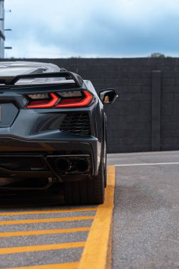 Chevrolet Corvette C8 arka stop lambası ve egzoz, spor araba arka manzarası kentsel asfalta park edilmiş.