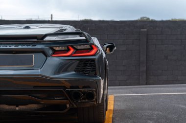 Chevrolet Corvette C8 arka stop lambası ve egzoz, spor araba arka manzarası kentsel asfalta park edilmiş.