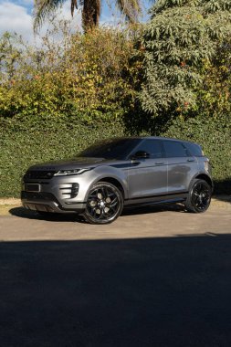 Gri Range Rover Evoque ön manzara üç çeyrek, lüks SUV yeşil çimenlerin önüne park edilmiş.