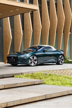 Yeşil Jaguar F tipi ön üç çeyreklik beyaz kapaklı, üstü açık spor araba gündüz vakti.