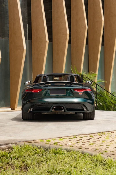 Koyu yeşil Jaguar F tipi dikiz aynası merkezli, lüks spor araba modern çıkıntılarda.