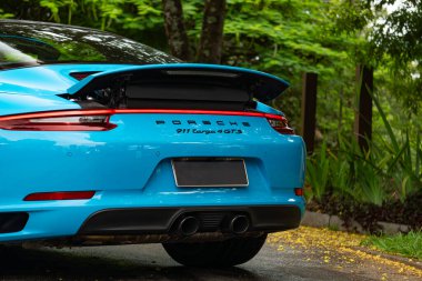 Mavi Porsche 911 Targa 4 GTS arka kapak, konforlu spor araba yolu manzaralı.