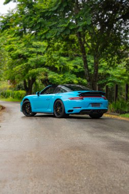 Mavi Porsche 911 Targa 4 GTS arka üç çeyreklik bahçe yolunda park edilmiş lüks spor araba