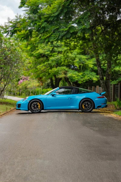 Mavi Porsche 911 Targa 4 GTS yan profili, çatısı orman yolunda kapalı lüks spor araba