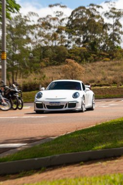 Beyaz Porsche 911 GT3 ön üç çeyrek, şehir otobanındaki yüksek performanslı spor araba.