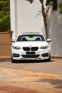 Beyaz BMW M235i ön manzara, beyaz binanın önünde lüks spor coupe