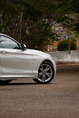 Beyaz BMW M235i ön tekerlek odaklı çekim, lüks spor sedan ön taraf görünümü