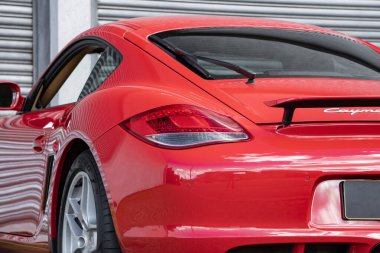 Kırmızı Porsche Cayman 'ın arka tarafı yakın çekim, lüks spor araba arka lambası ve kanat detayları