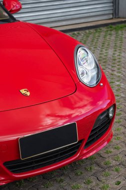 Kırmızı Porsche Cayman 's ön ucu aşağı logo ve far, lüks spor coupe ön detayları