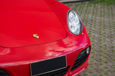 Kırmızı Porsche Cayman 's ön ucu aşağı logo ve far, lüks spor coupe ön detayları