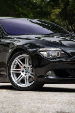 Siyah BMW 650i ön tekerlek ve ön farlar, asfalt yolda park edilmiş lüks coupe.