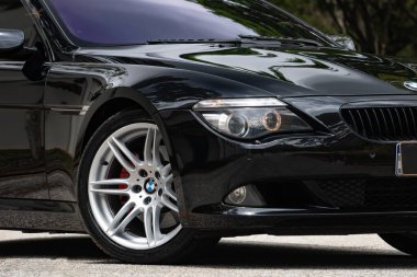 Siyah BMW 650i ön tekerlek ve ön farlar, asfalt yolda park edilmiş lüks coupe.