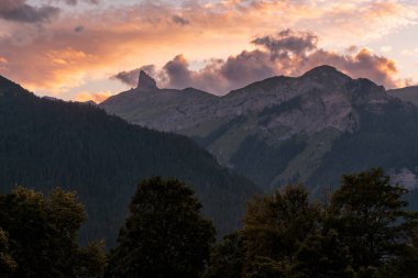 Yazın, Lauterbrunnen yakınlarındaki Bernese Alplerinde dramatik turuncu bulutlarla gün batımı. Wengen, Bernese Oberland, İsviçre