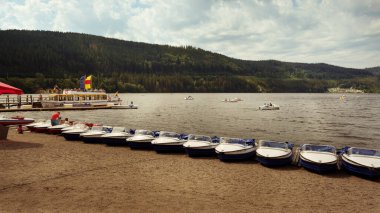 Titisee-Neustadt, Baden-Wurttemberg, Almanya - 28 Temmuz 2020: Kara Orman 'daki Titisee Gölü' ne bakan küçük turist botları kıyılarda dizildi
