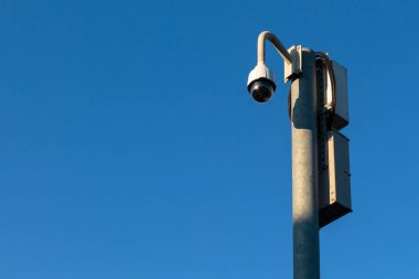 360 derece CCTV güvenlik kamerası mavi gökyüzü arka planındaki bir direğe sabitlendi - güvenlik, büyük kardeş konsepti - manzara yönelimi