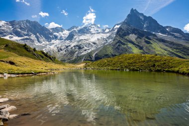 İsviçre 'nin Val d' Anniviers kentindeki Weisshorn ve Besso tepelerini yansıtan Lac d Arpitettaz 'ın nefes kesici panoramik manzarası. İsviçre seyahat ve turizm için Alp manzarası