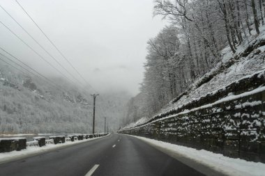 Arabalar karla kaplı ağaçlar ve sisli dağlarla dolu bir yolda ilerliyor. Kış havası yol kenarında beyaz bir manzara yaratır. Sahne sezonun soğuğunu gösteriyor. Valea Oltului Iarna.