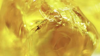 Bal, kavanozdan mutfak tezgahındaki cam kaseye dökülüyor. Sıcak ışık, akan balın pürüzsüz dokusunu vurgular..