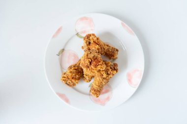 Kızarmış tavuk ve beyaz tabak.