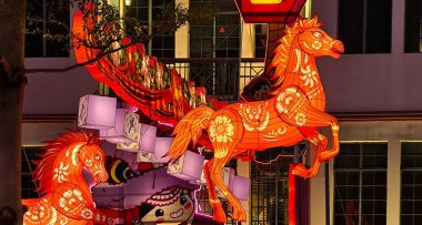 Singapur-2 Ocak 2026.Renkli ikiz at fenerleri Çin Yeni Yılı veya Fener Festivali ortamında sergilendi. Bir at dramatik bir şekilde dikilirken diğeri hazır duruyor, her ikisi de karmaşık çiçek motifleriyle süslenmiş..