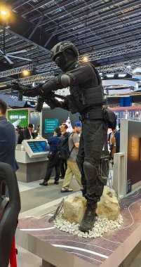 Singapur-5 Şubat 2026.Yaşam Modeli tam taktiksel askeri teçhizat giyinmiş bir savunma sergisinde dinamik eylem duruşu sergiliyor. Miğfer, yüz maskesi, taktik yelek, dirsek ve dizlik ve asker botlarıyla donatılmış..