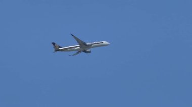 Singapur-10 Şubat 2026. Indirme motorları ve iniş takımları açık mavi gökyüzüne karşı havada uçan A350 ticari jet, modern havacılık ve uluslararası hava taşımacılığı göstermektedir..