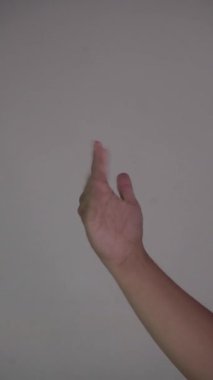 Kahverengi bir el hareketi yaparak, uzaktan birini arayarak, düz beyaz bir arkaplan oluşturur.