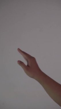 Bronzlaşmış bir elin dijital teknoloji kullanıyormuşçasına sürtünmesi ve sıkıştırılması, düz beyaz arkaplan