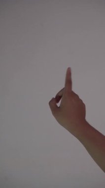 Bronzlaşmış bir elin dijital teknoloji kullanıyormuşçasına sürtünmesi ve sıkıştırılması, düz beyaz arkaplan