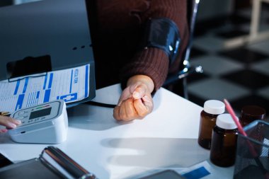 Bir doktorun elleri dikkatle hastanın kan basıncını ölçmek için sfenometre kullanıyor..