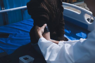 Doktor genç kızı muayene ediyor, kan basıncını ölçüyor, tansiyon monitörü kullanıyor. Okula giriş sınavı kavramı.