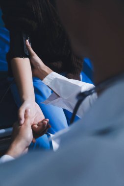 Doktor genç kızı muayene ediyor, kan basıncını ölçüyor, tansiyon monitörü kullanıyor. Okula giriş sınavı kavramı.