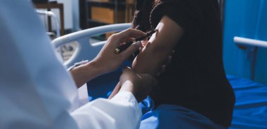 Hastanedeki doktor, kadının kan basıncını ve nabzını ölçmek için manuel tansiyon monitörü kullanıyor..