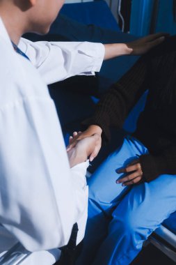 Doktor hastanın elini tutuyor ve ona destek oluyor.