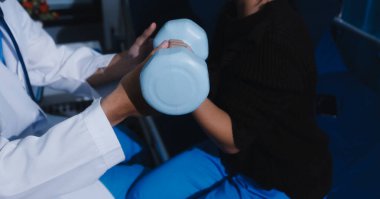 Tanımlanamayan fiziksel terapi sırasında mavi el ağırlığı kullanır