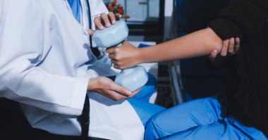 Tanımlanamayan fiziksel terapi sırasında mavi el ağırlığı kullanır