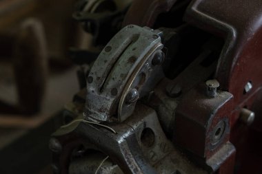 Metal tekerlekler, gerilim yayları, dişliler, vidalar, vidalar, bobbin mekanizmaları dahil olmak üzere çeşitli eski vintage dikiş makinesi parçalarının yakın plan detaylı fotoğrafı, ve eski patina ile kırsal bir kompozisyonda düzenlenmiş karmaşık mekanik bileşenler