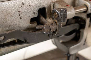 Metal tekerlekler, gerilim yayları, dişliler, vidalar, vidalar, bobbin mekanizmaları dahil olmak üzere çeşitli eski vintage dikiş makinesi parçalarının yakın plan detaylı fotoğrafı, ve eski patina ile kırsal bir kompozisyonda düzenlenmiş karmaşık mekanik bileşenler