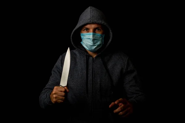 Mladý Muž Lékařské Masce Ukazuje Prstem Zatímco Drží Nůž Černém — Stock fotografie