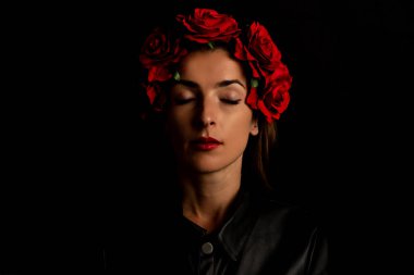 Siyah arka planda çelenk takmış, gözleri kapalı genç bir kadın.